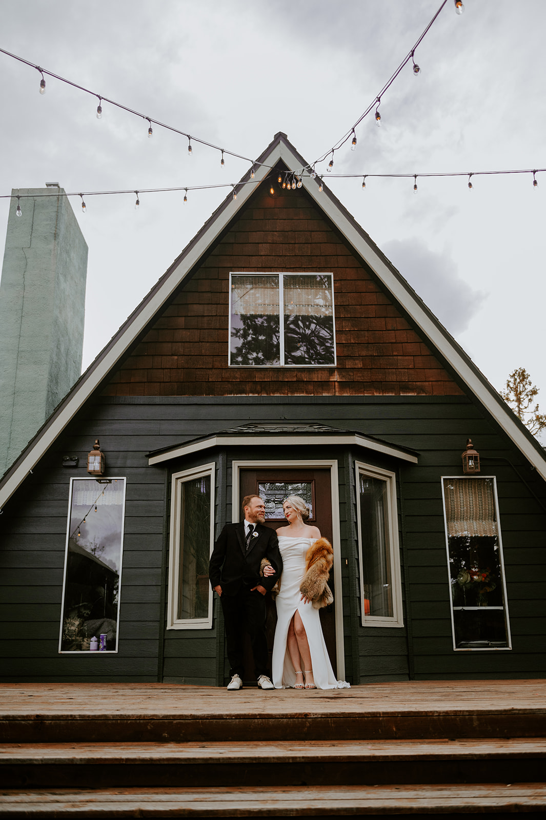 Bride and groom in front of their A-Frame home in Bend