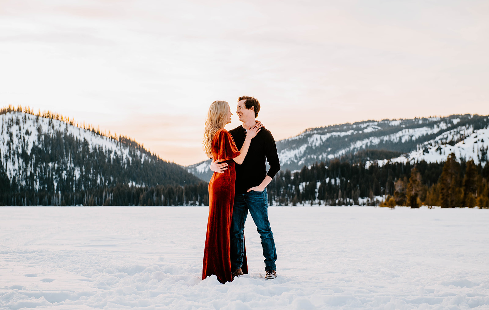 A couple looking at each other in the snow at sunset in the central oregon cascades