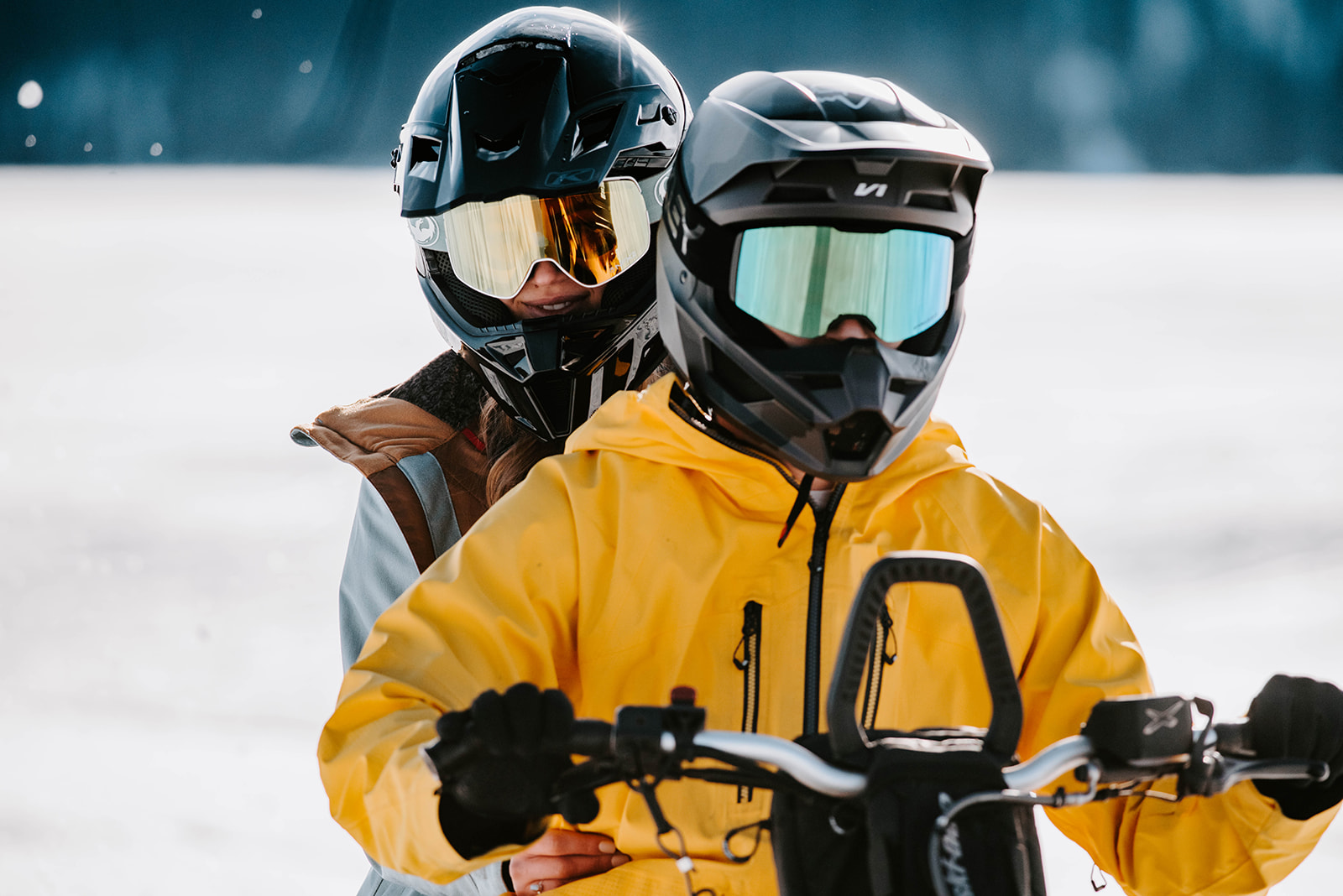 A couple riding a snowmobile together