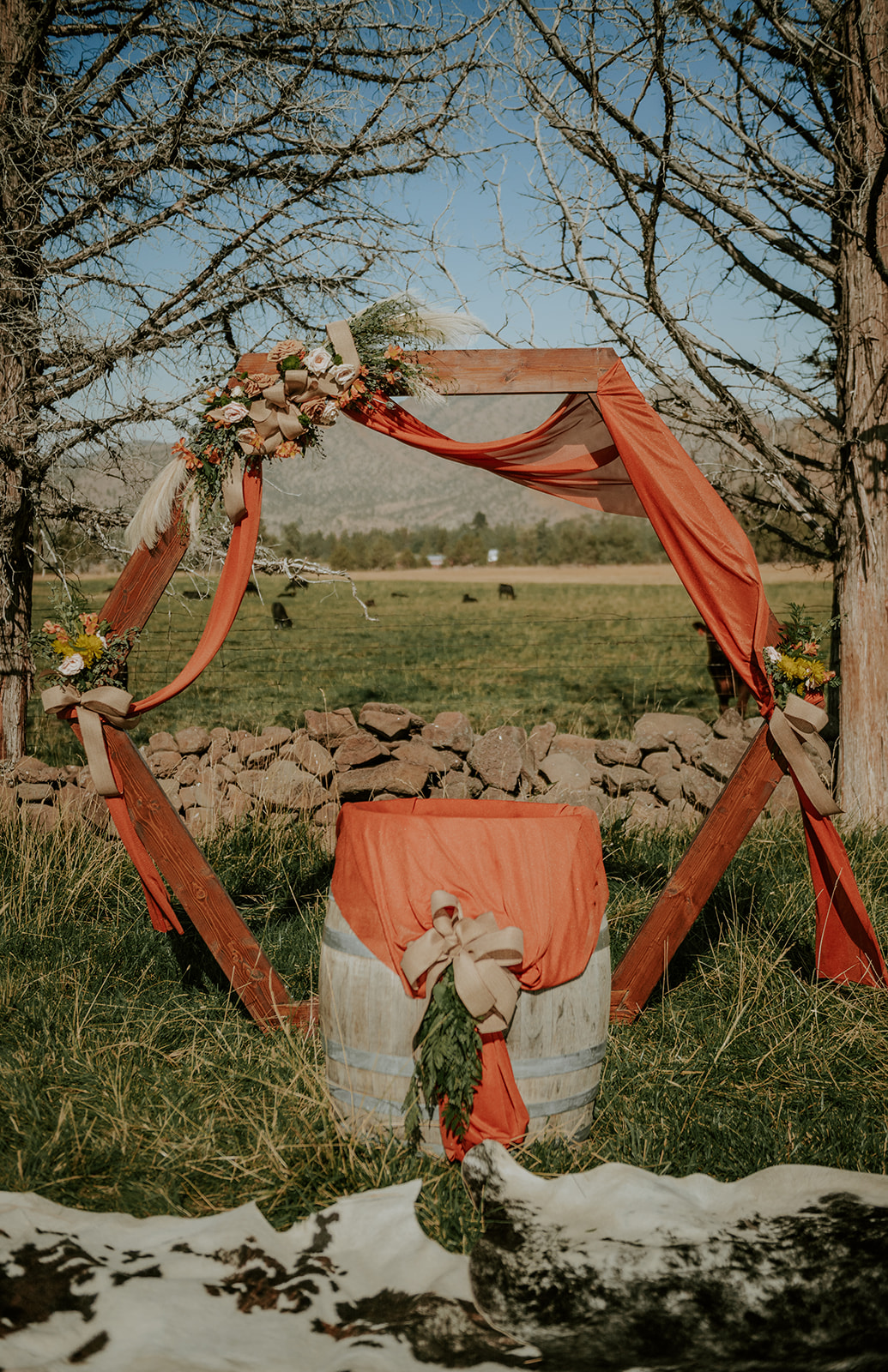 Country chic orange and cow hide rug wedding arch 