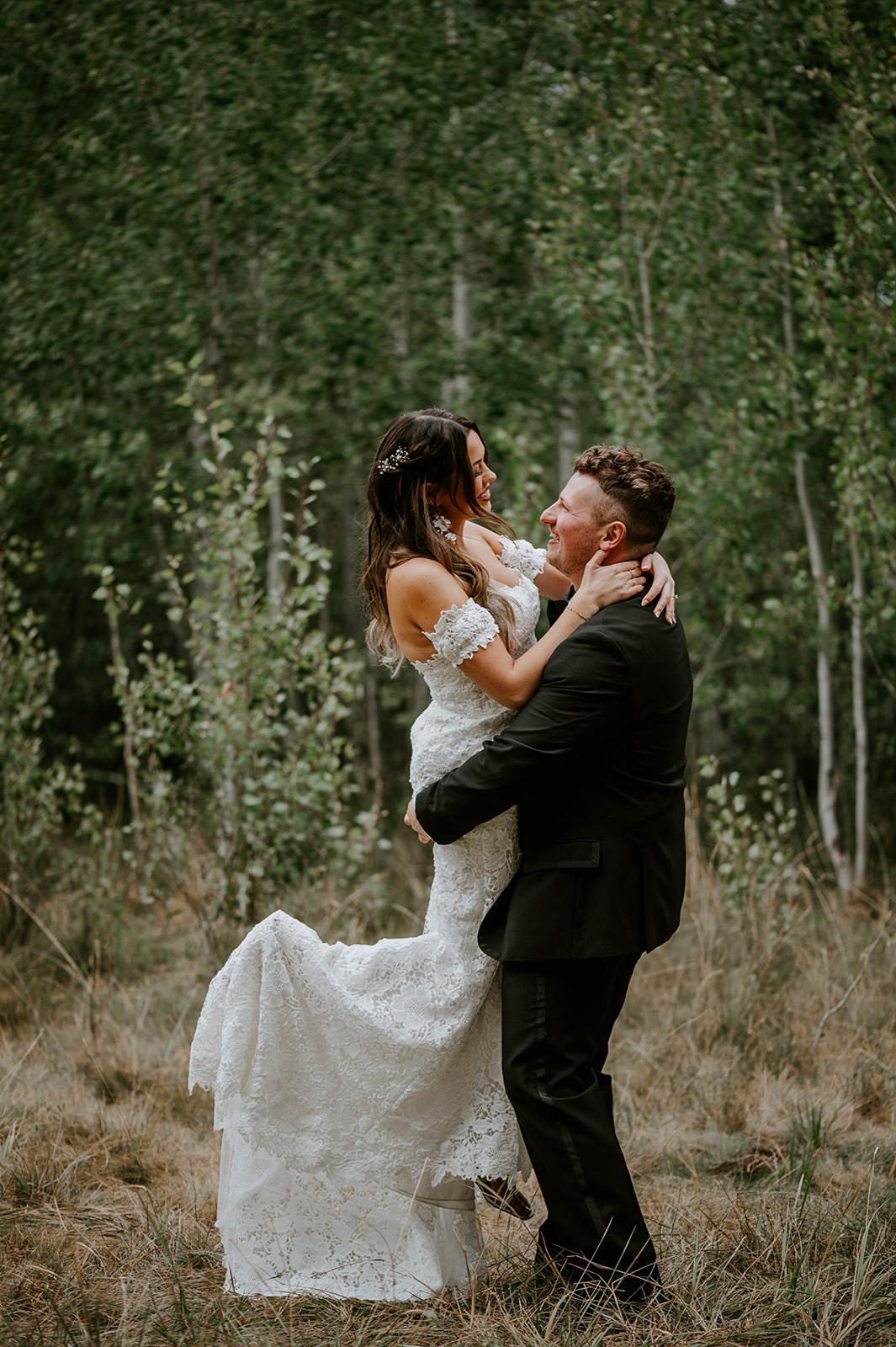 Groom picks bride up and spins her around in the aspen groves at shevlin park