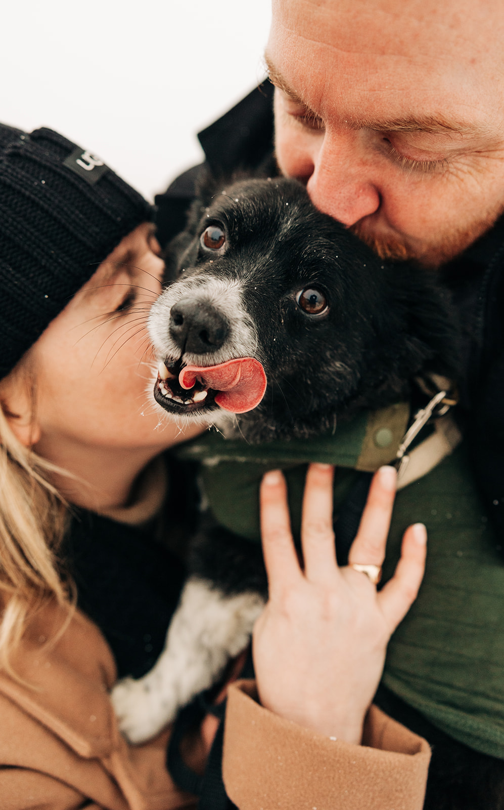 man and woman kissing their dog