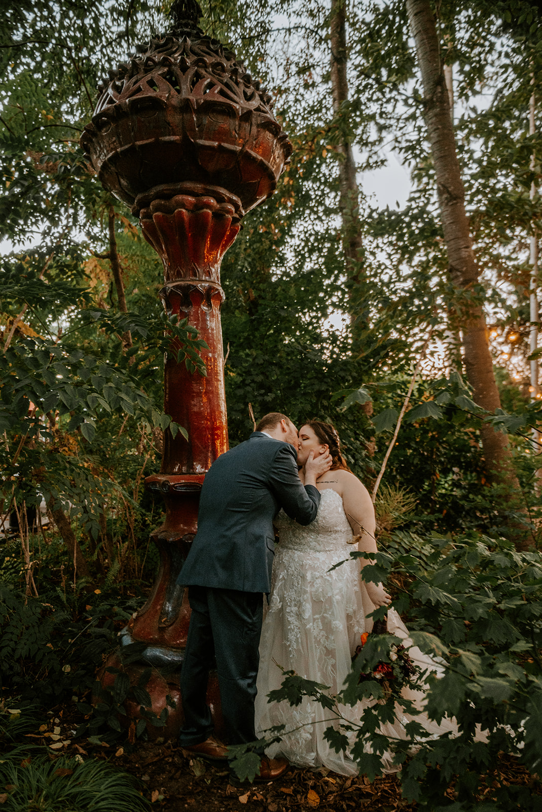 Bride and groom kissing at statue in the garden at the McMenamins Cornelius Pass Roadhouse 