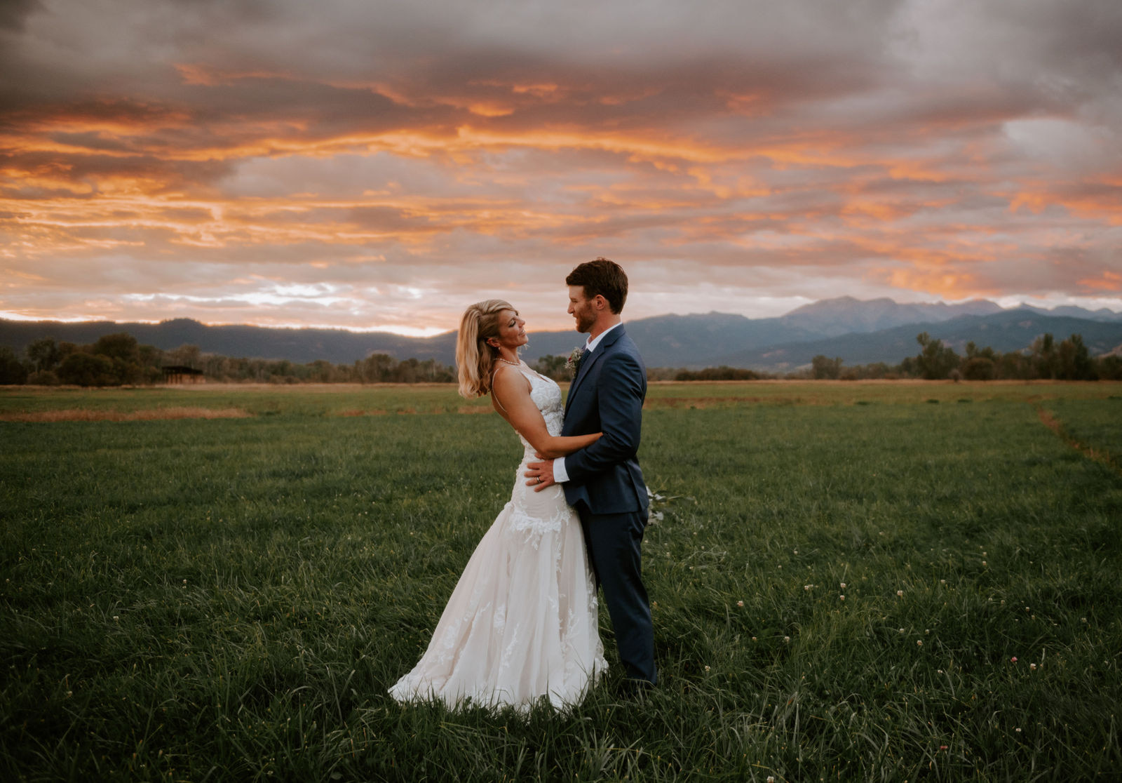 Bride and groom embracing under the autumn sunset at the base of the wallowa mountains.