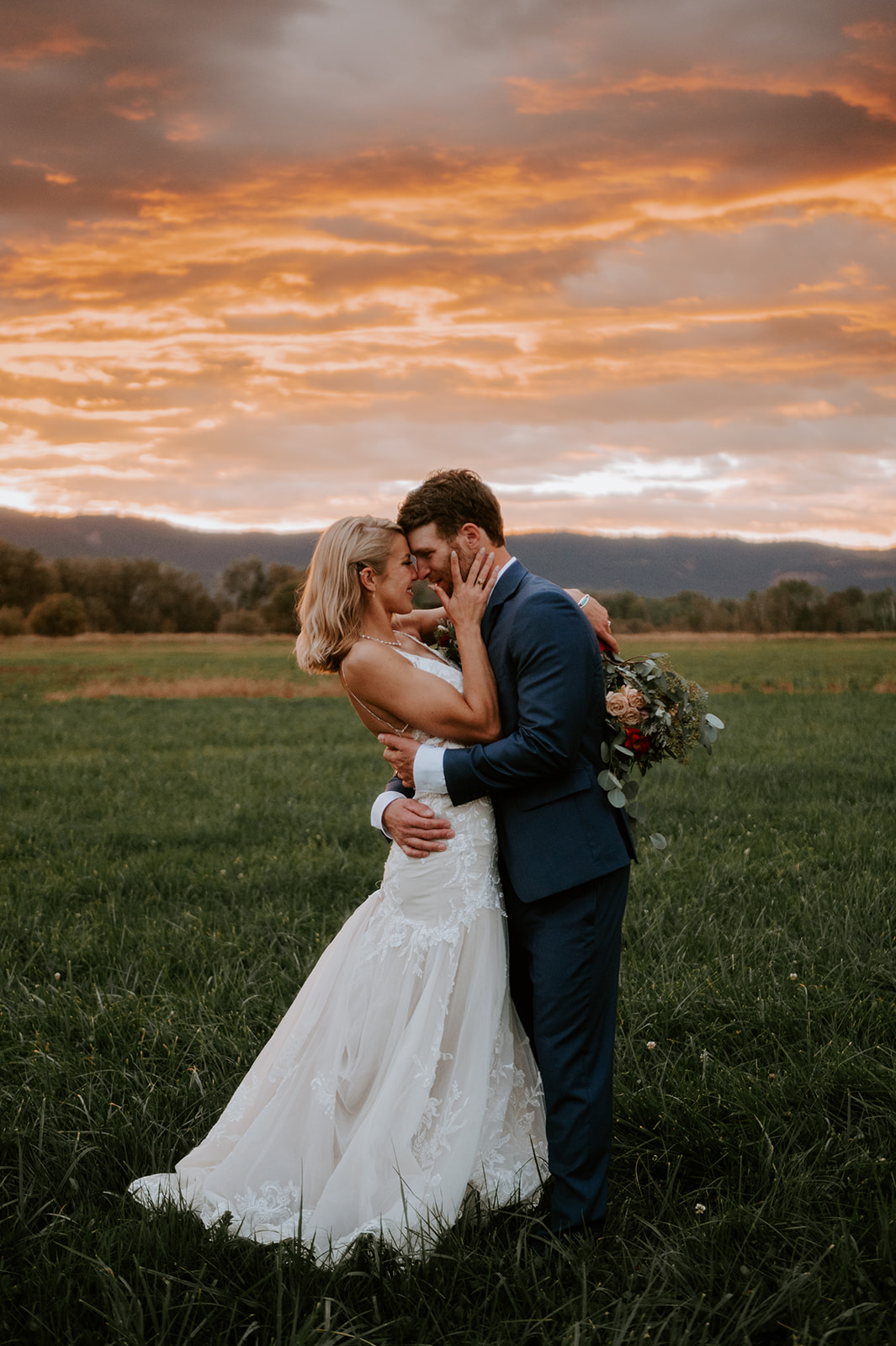 Bride and groom kissing under pink sunset in the wallowas 