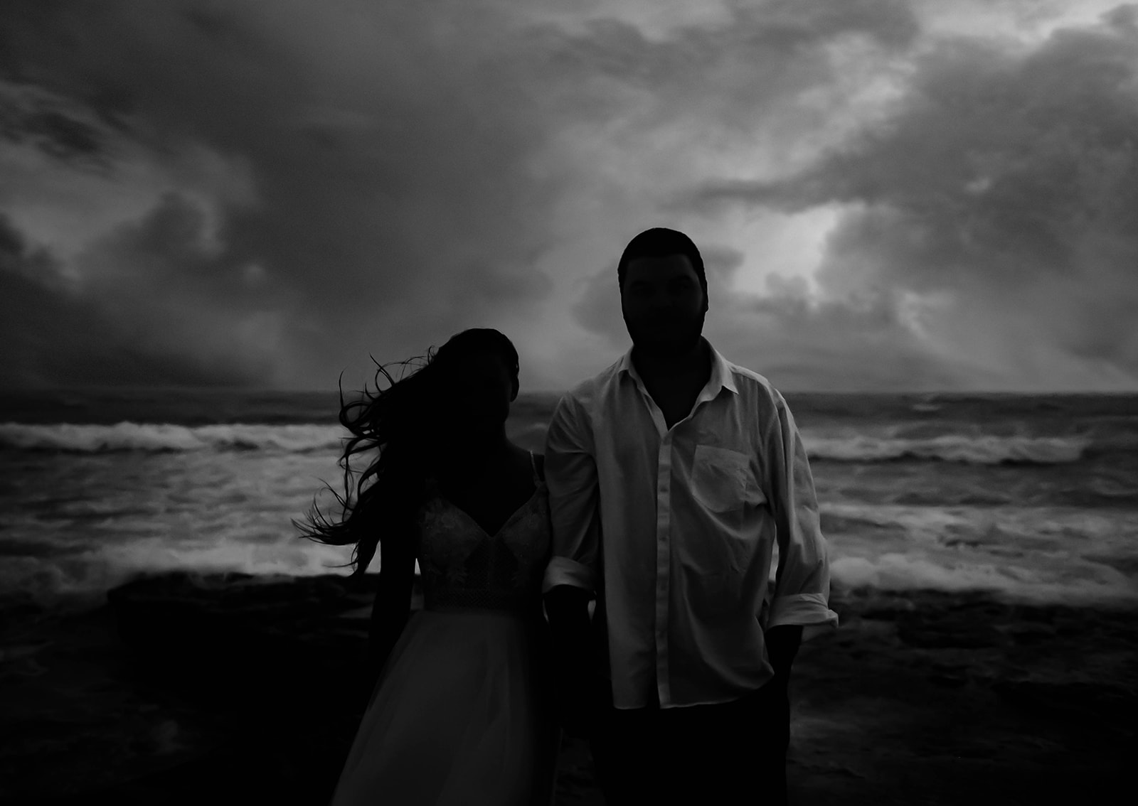 Bride and groom hand in hand during a hurricane