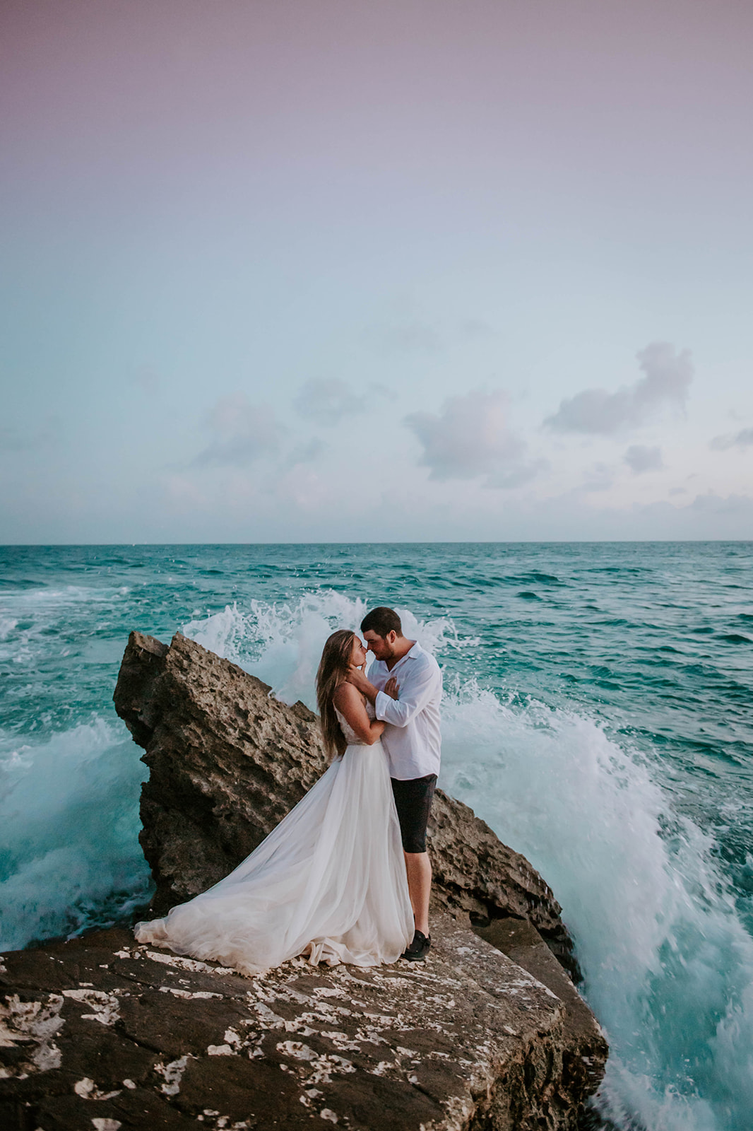 Bride and groom kissing with the carribean sea in the background