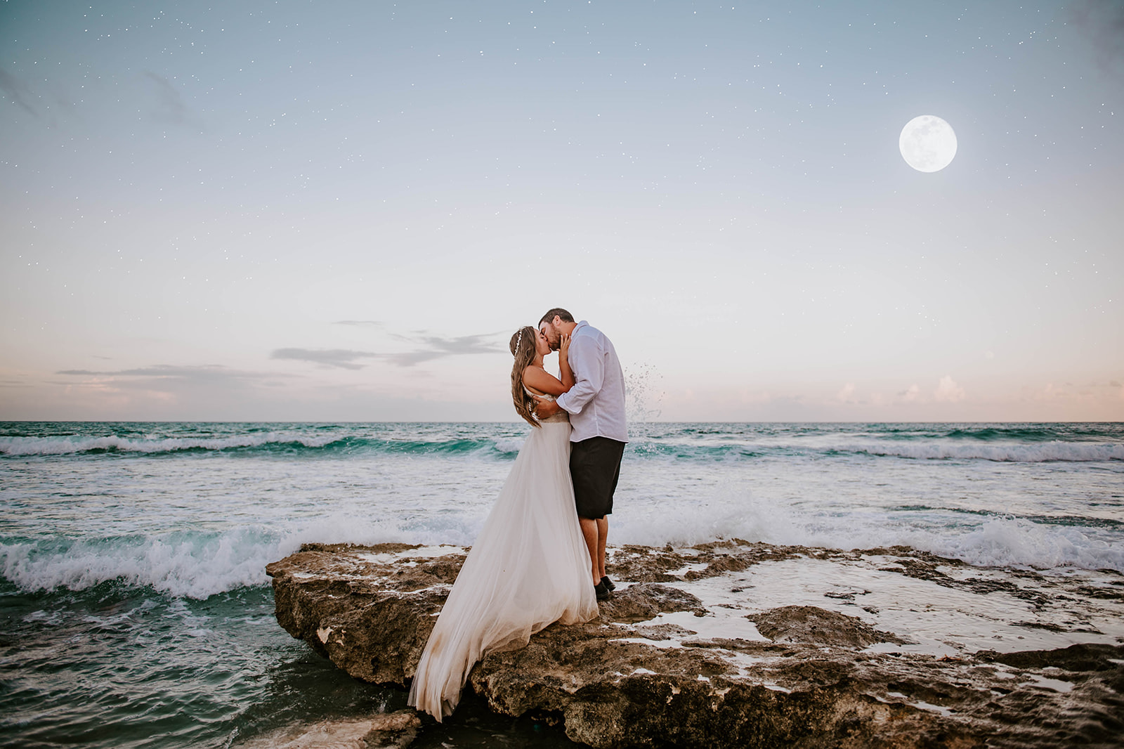  A couple who just got married kissing under the full moon on the island of Isla Mujeres