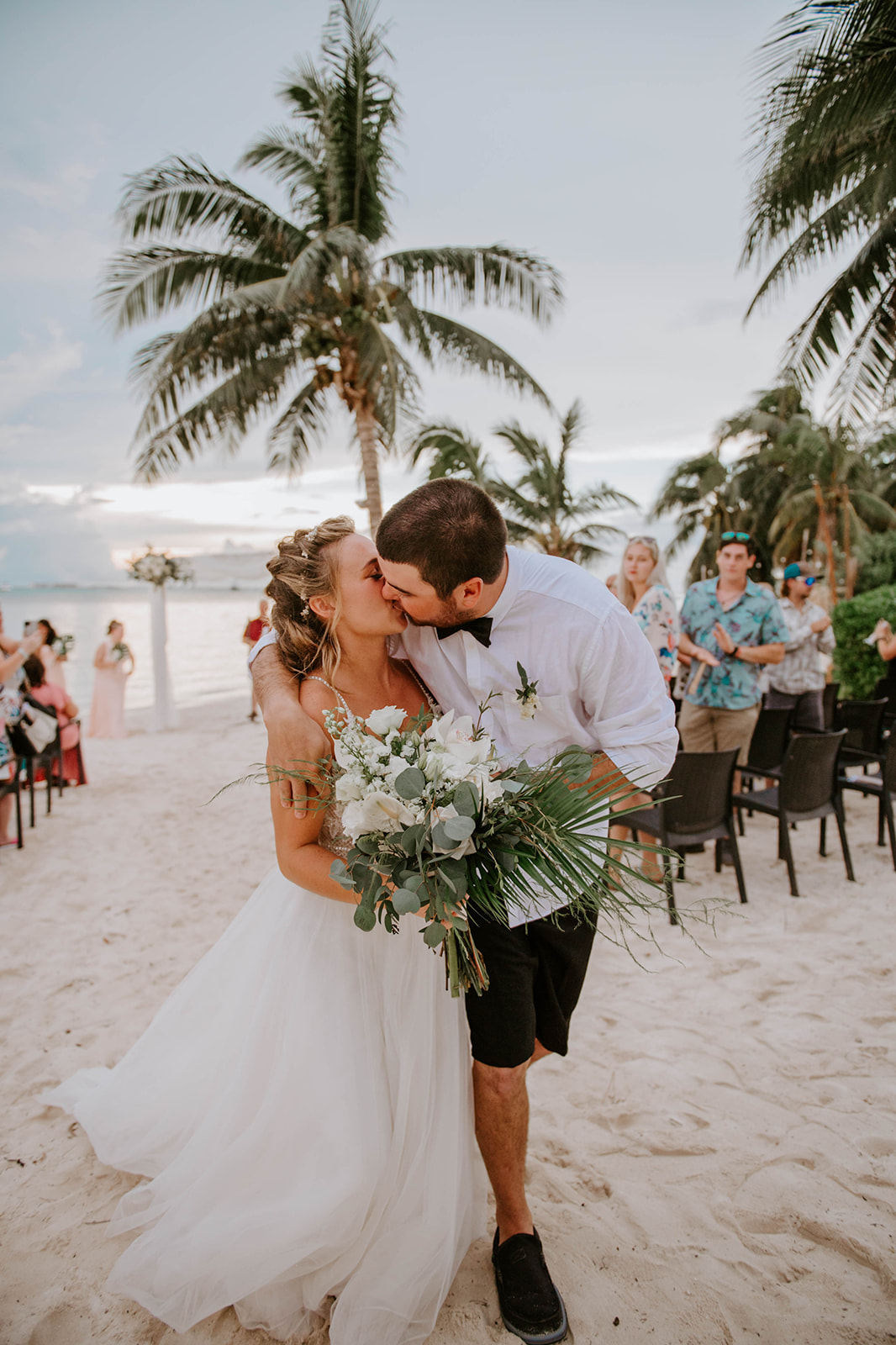Groom kissing bride at the end of the aisle at Zama yacht and beach club