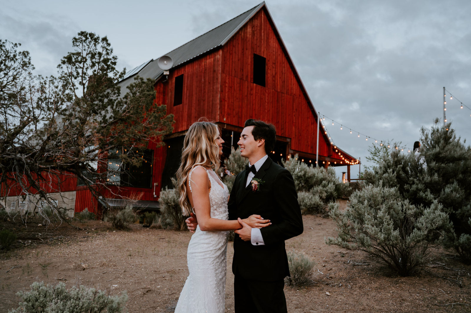 Bride and groom dance together in front of the reception barn at Brasada Ranch in Bend, Oregon