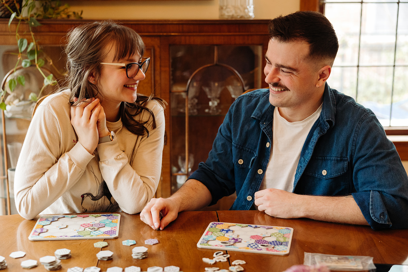 Couple plays their favorite board game during their at home engagement photo session