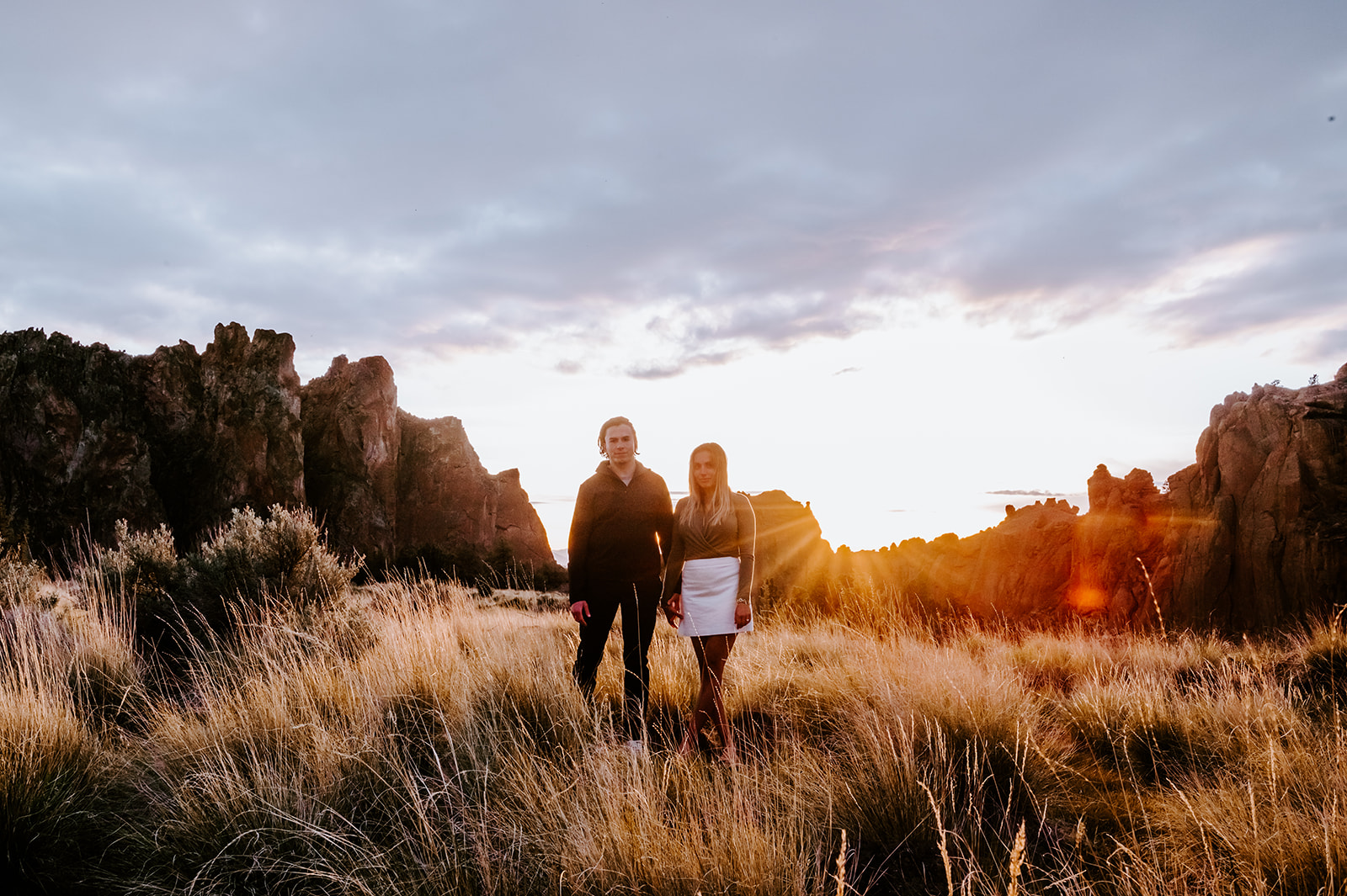 Couple looks at the camera during sunset at smith rock after getting engaged