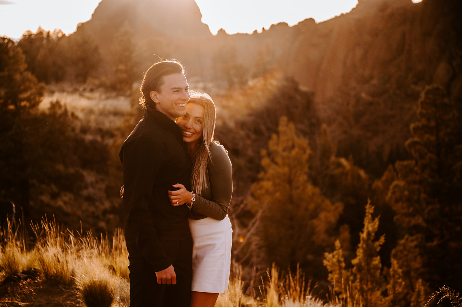 Newly engaged couple embracing during golden hour at smith rock