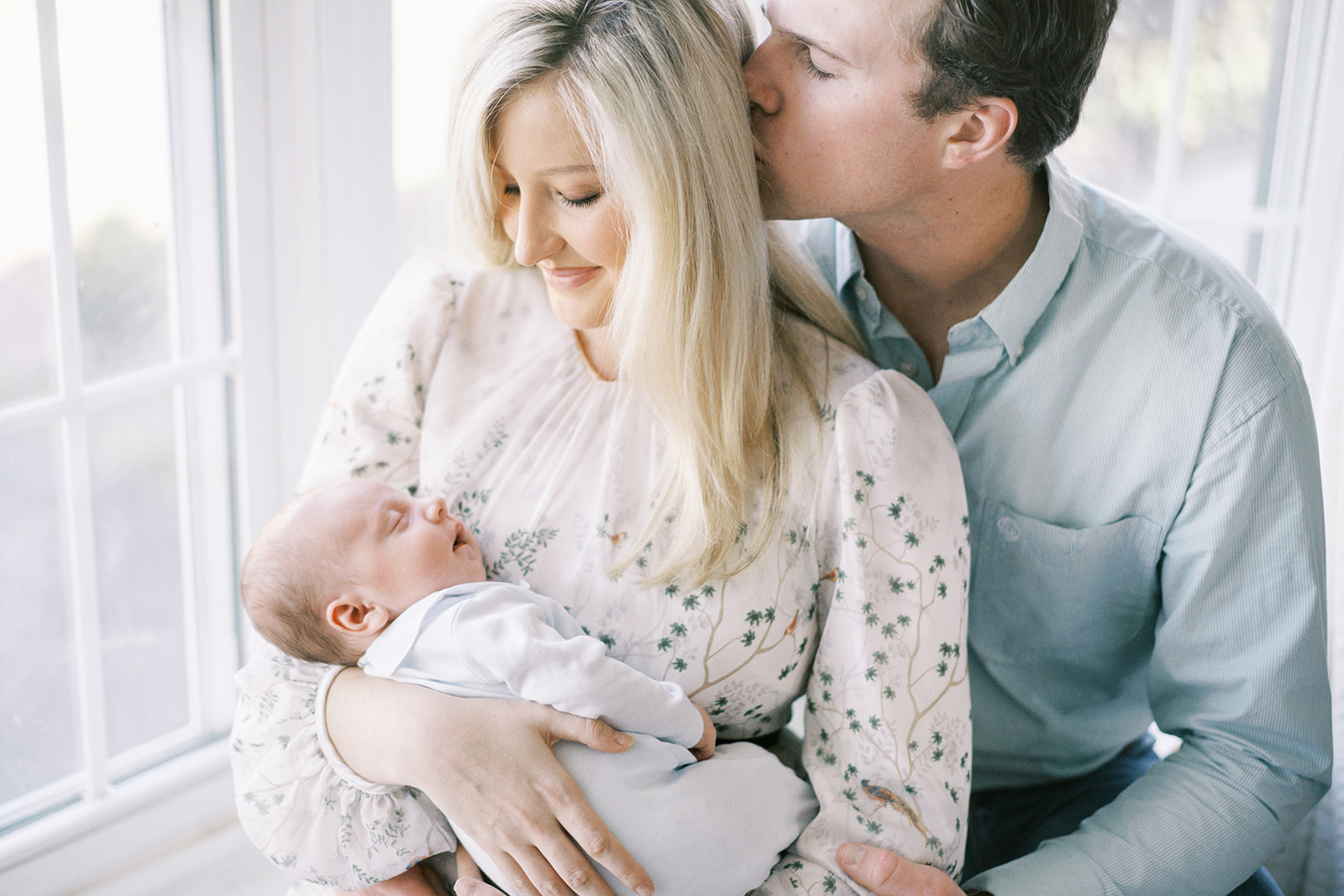 The Willoughby family gathers in front of the window with their new baby boy