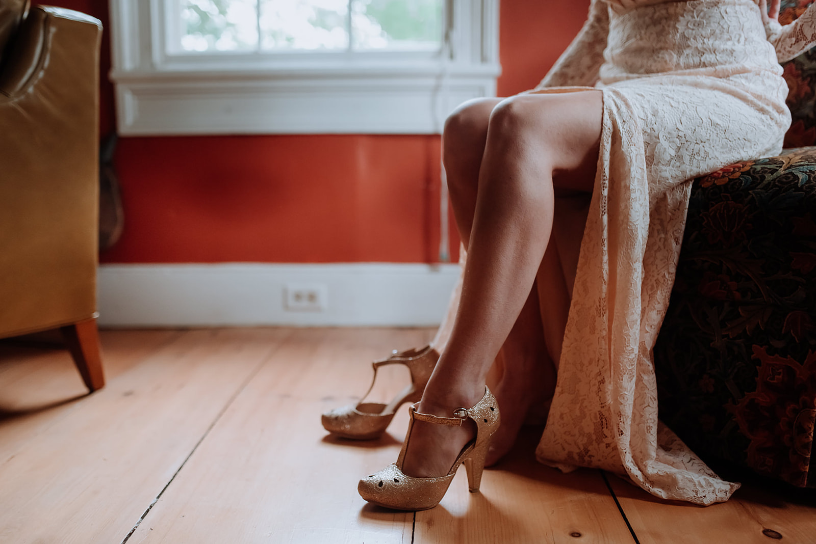 Close up of Bride's legs as she slides her foot into her ankle strap high heels.