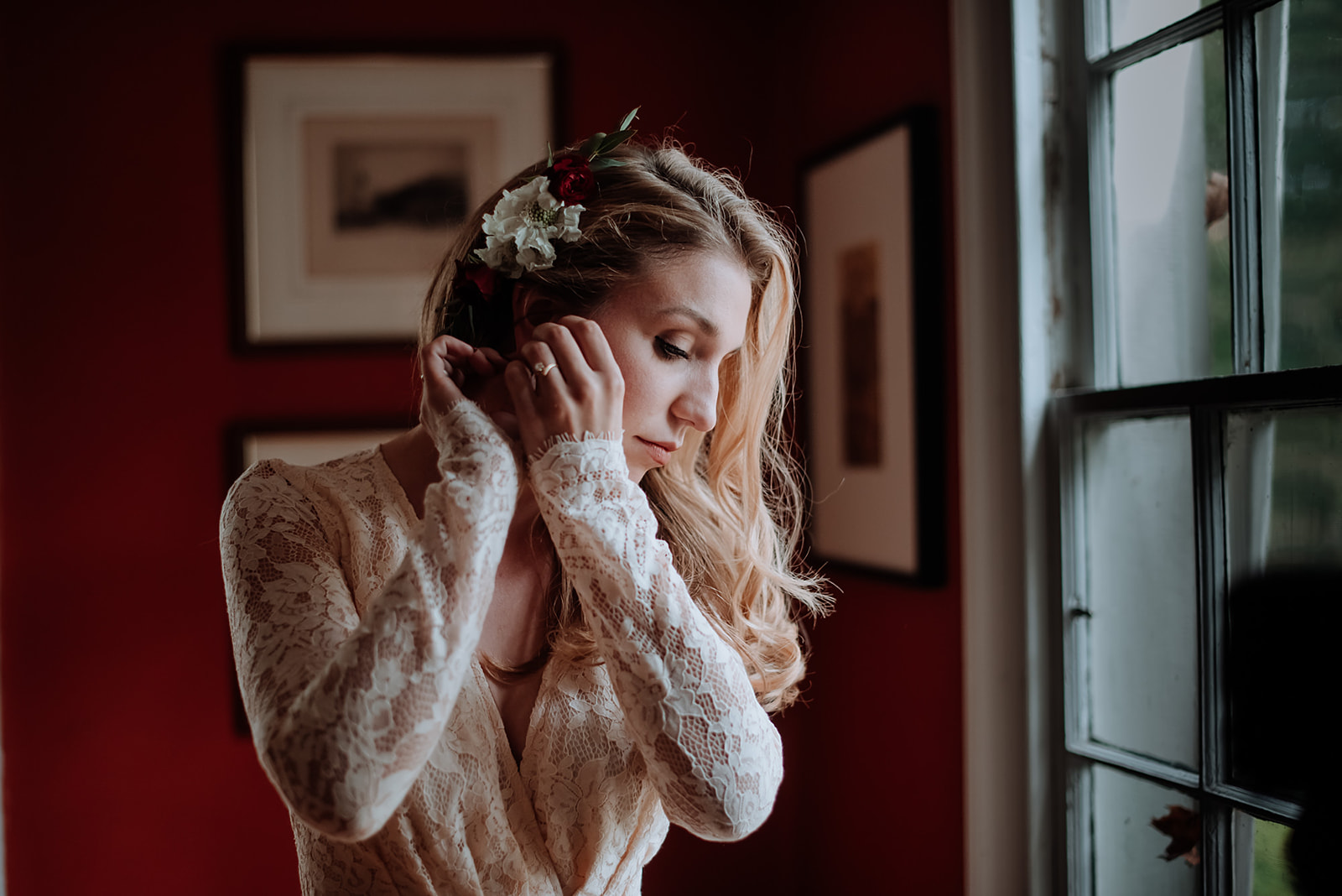 Natalie's long sleeved vintage lace wedding dress fits her perfectly as she puts her earrings on.