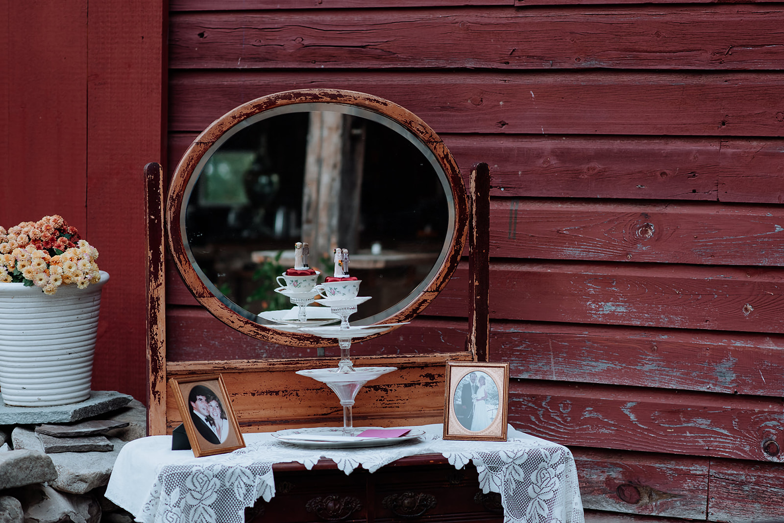 Old antique dresser with mirror holds cake plate and vintage wedding decor.