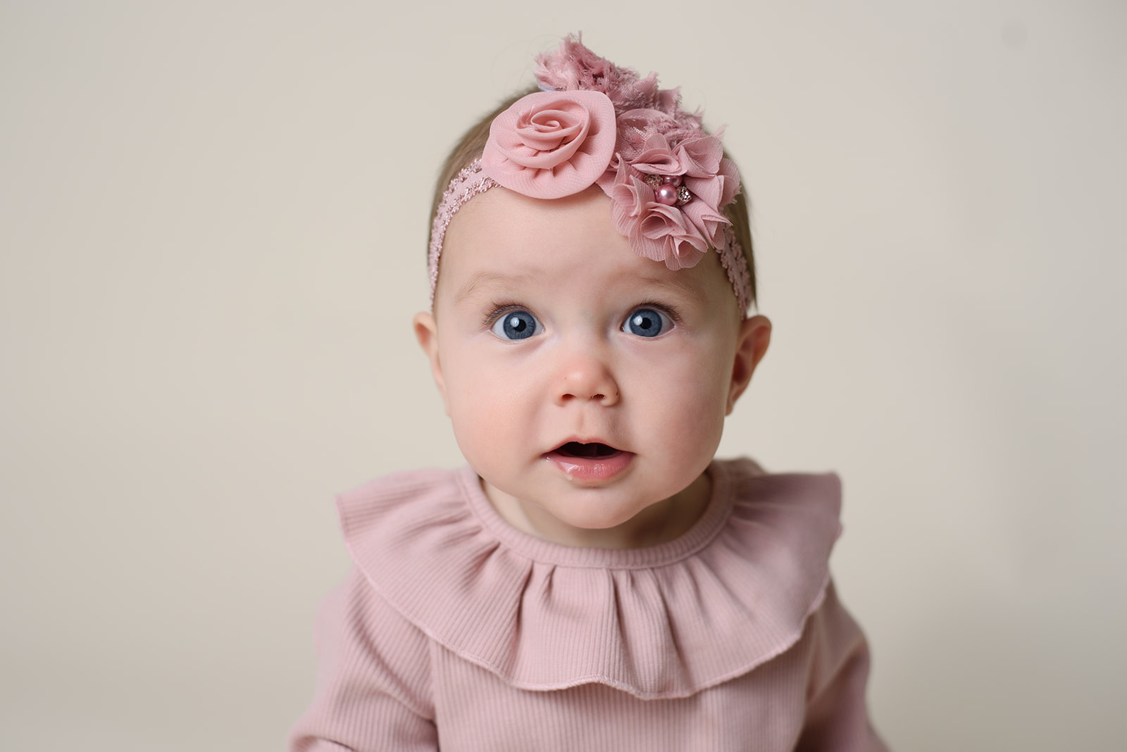 A baby girl stares into the camera while celebrating her 6 month milestone with Rachel Mummert Photography