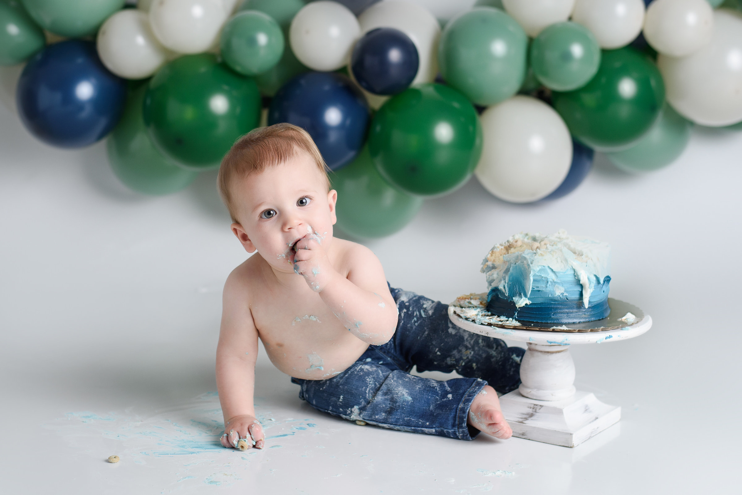 baby boy eats cake at his cake smash session