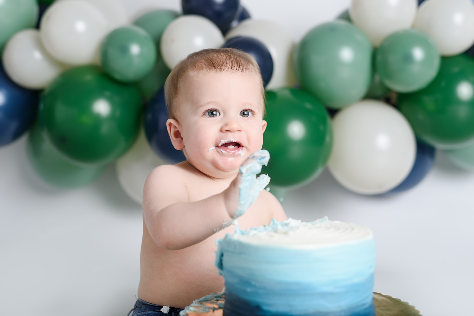 a baby gets messy during his cake smash at rachel mummert photography
