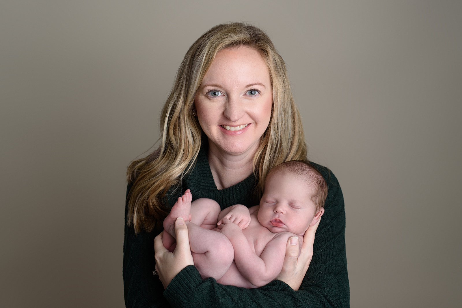 A new mom cradles her newborn baby during a photography session with Rachel Mummert Photography