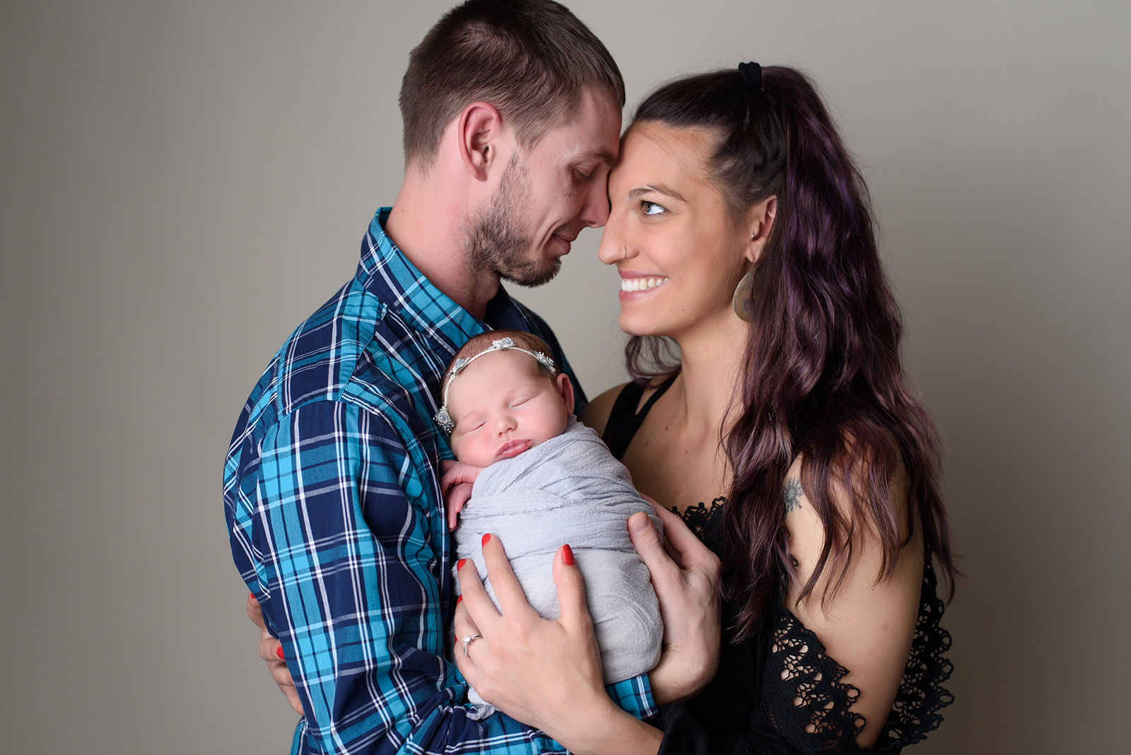 A couple poses with their new baby during a newborn session with Rachel Mummert Photography.