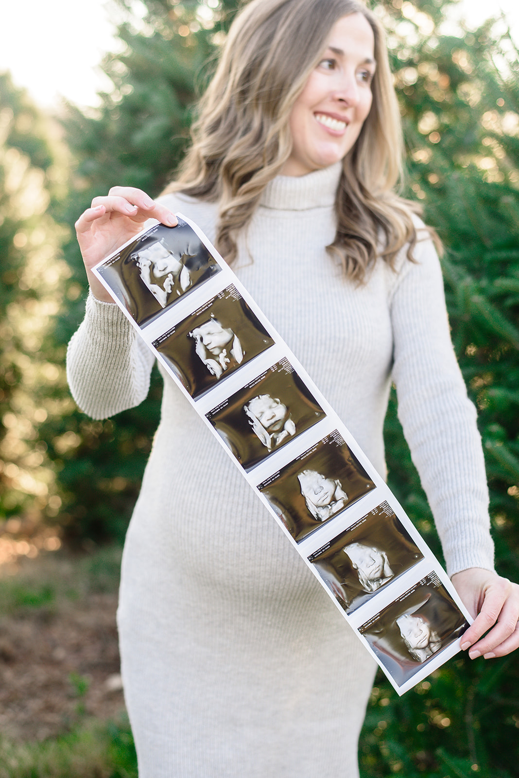 An expecting mother holds her ultrasound photos during her maternity session in Hanover PA with Rachel Mummert 