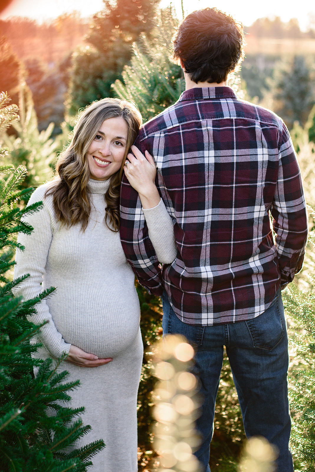 A pregnant mom smiles at the camera during their maternity photoshoot with Rachel Mummert Photography