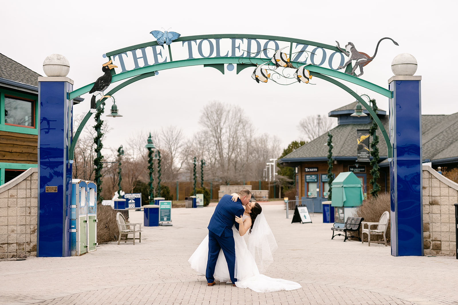 Bride and groom in front of the toledo zoo sign by Michele Maloney Photography