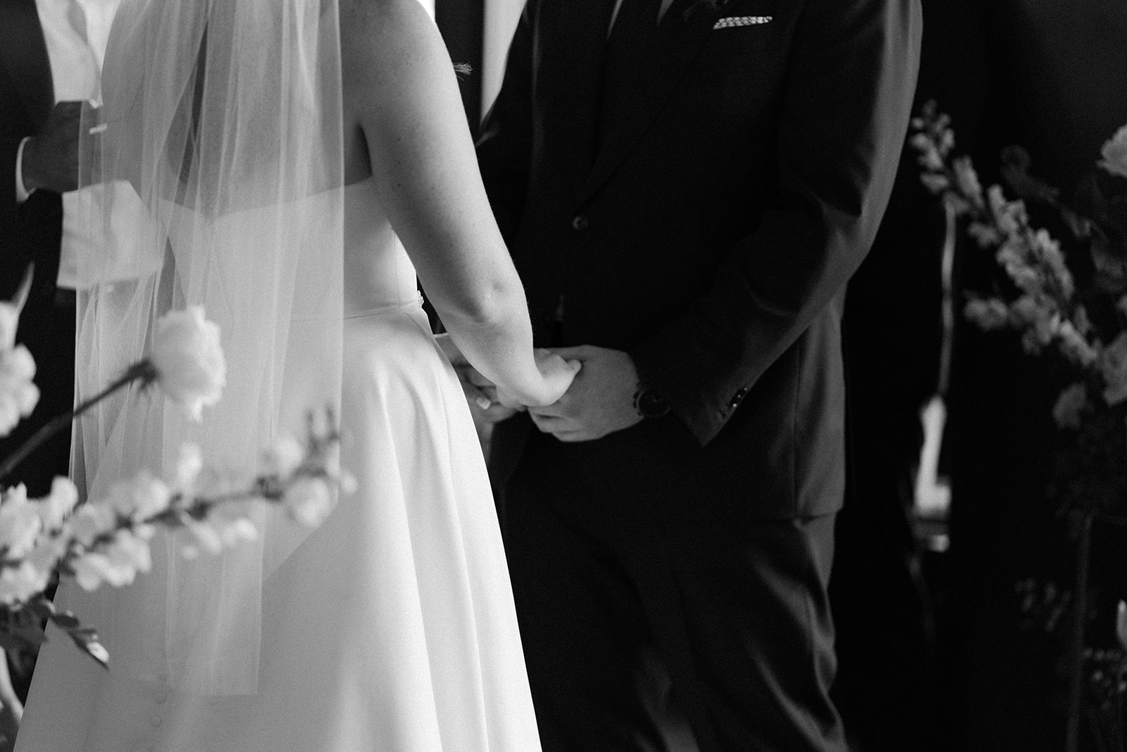 Black and white image of man and wife holding hands.