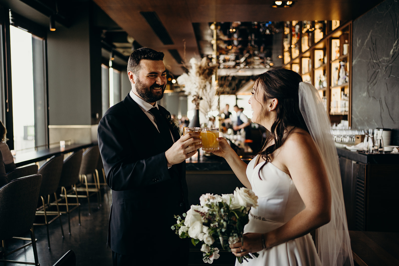 Man and wife holding drinks together looking at each other.