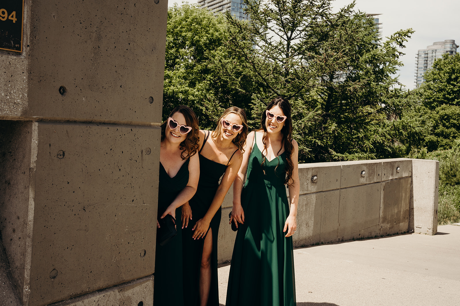 Three ladies with sunglasses smiling looking down the way.