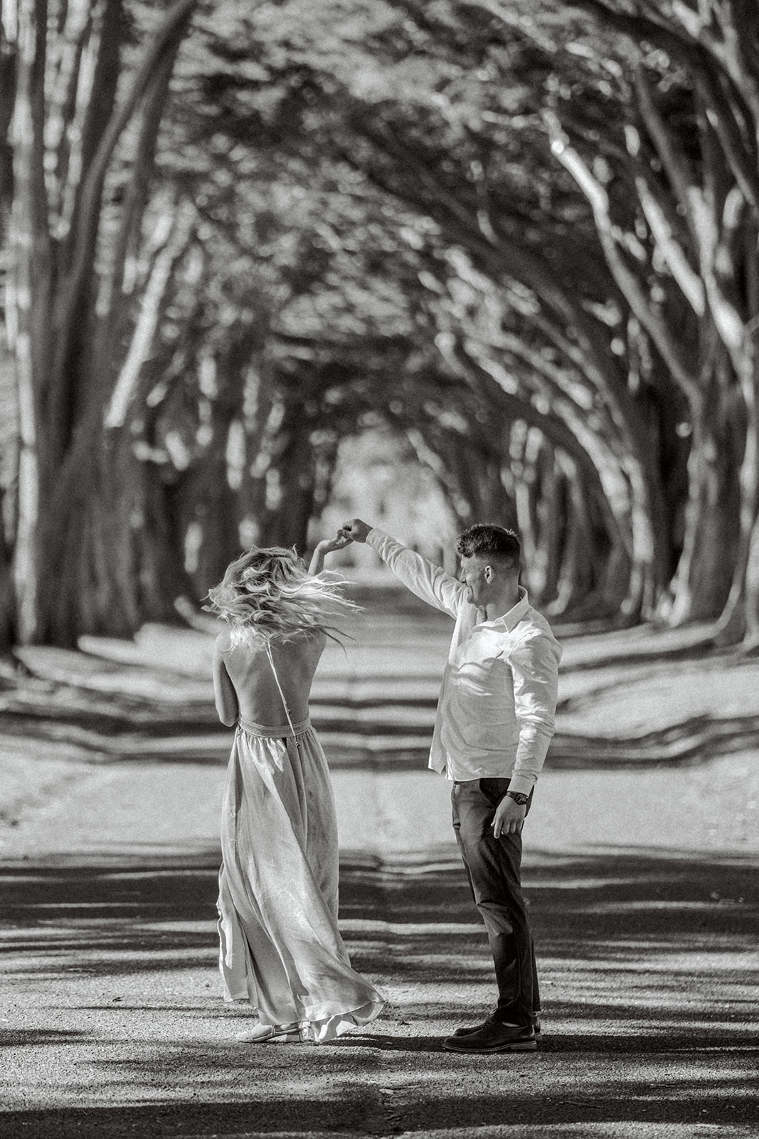 Film black and white Engagement couple at Cypress tree tunnel at Point Reyes CA
