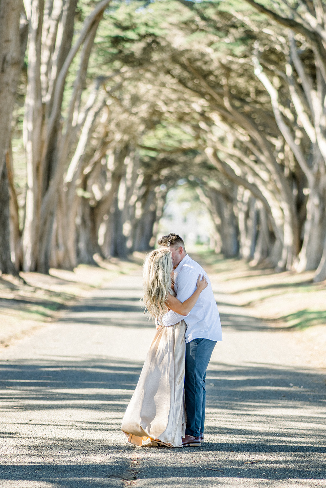 Kiss Engagement couple at Cypress tree tunnel at Point Reyes CA formal dress