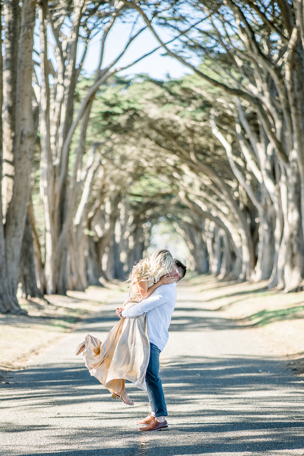 Lift kiss Engagement couple at Cypress tree tunnel at Point Reyes CA