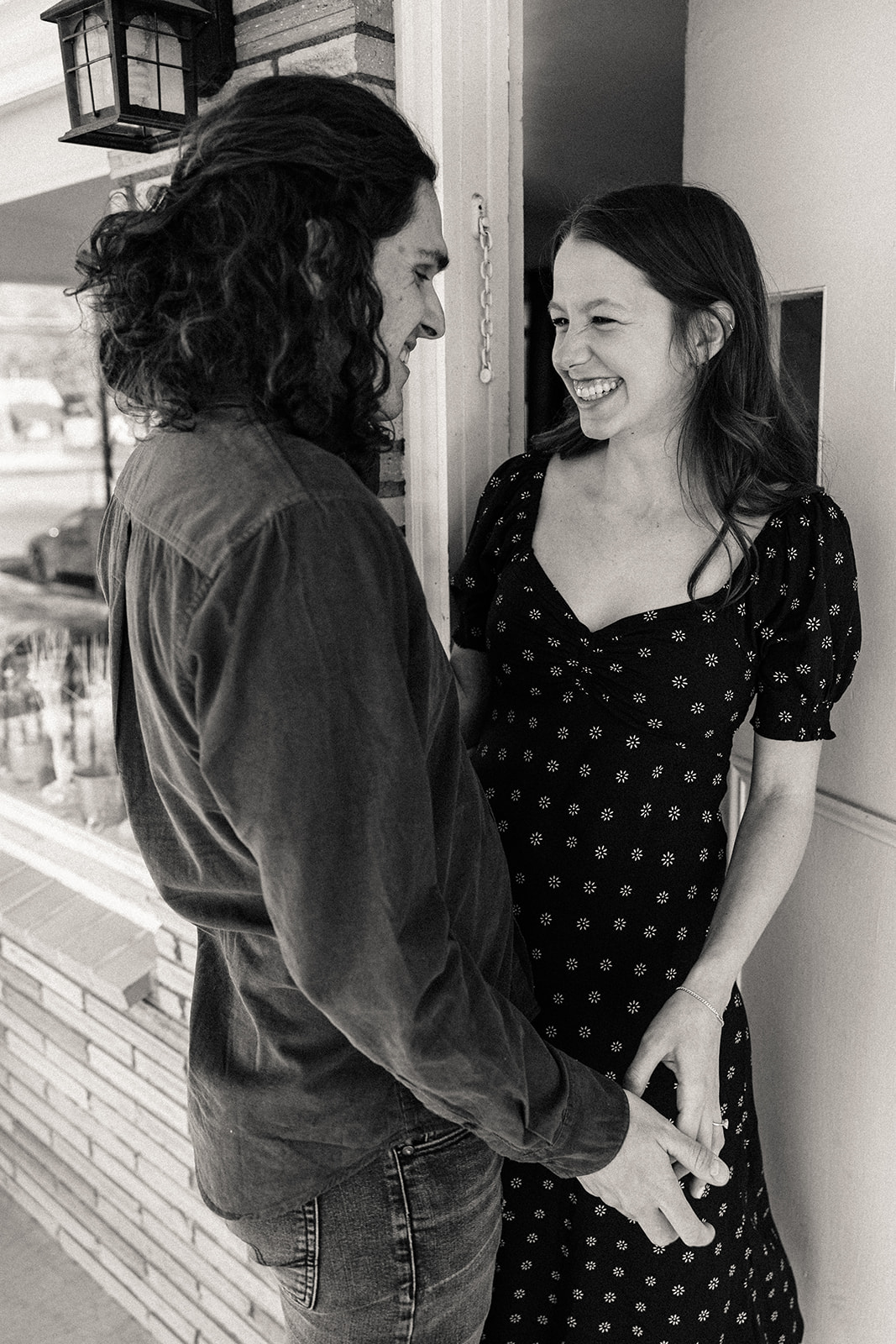 man and woman smiling at each other during their spring engagement session