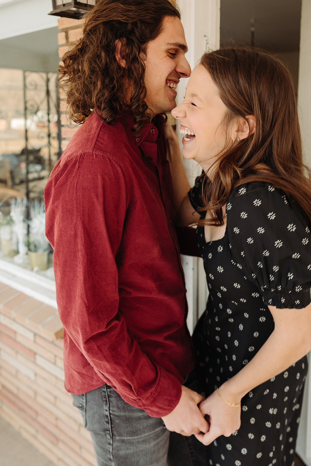 man and woman laughing while holding each other during spring engagement session