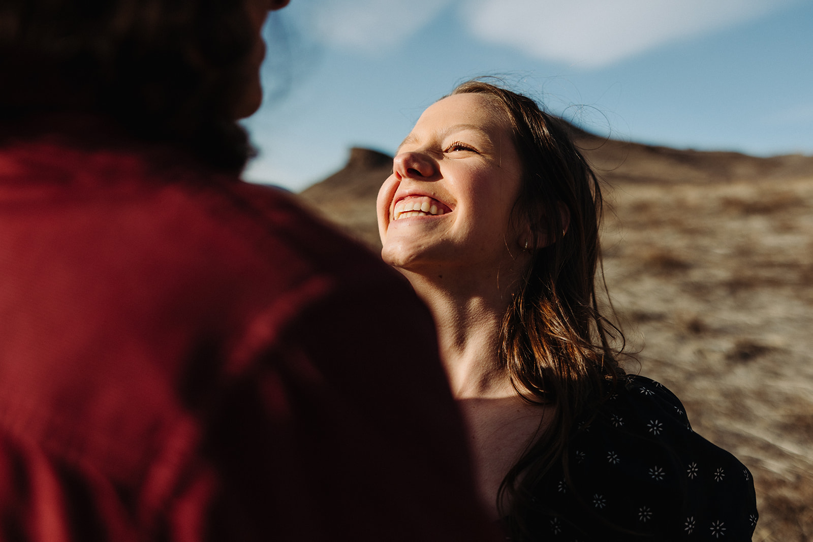 woman smiling at a man during their spring engagement session