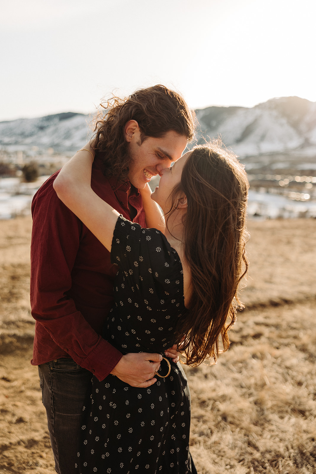 man and woman smiling at each other during their Colorado mountain engagement session