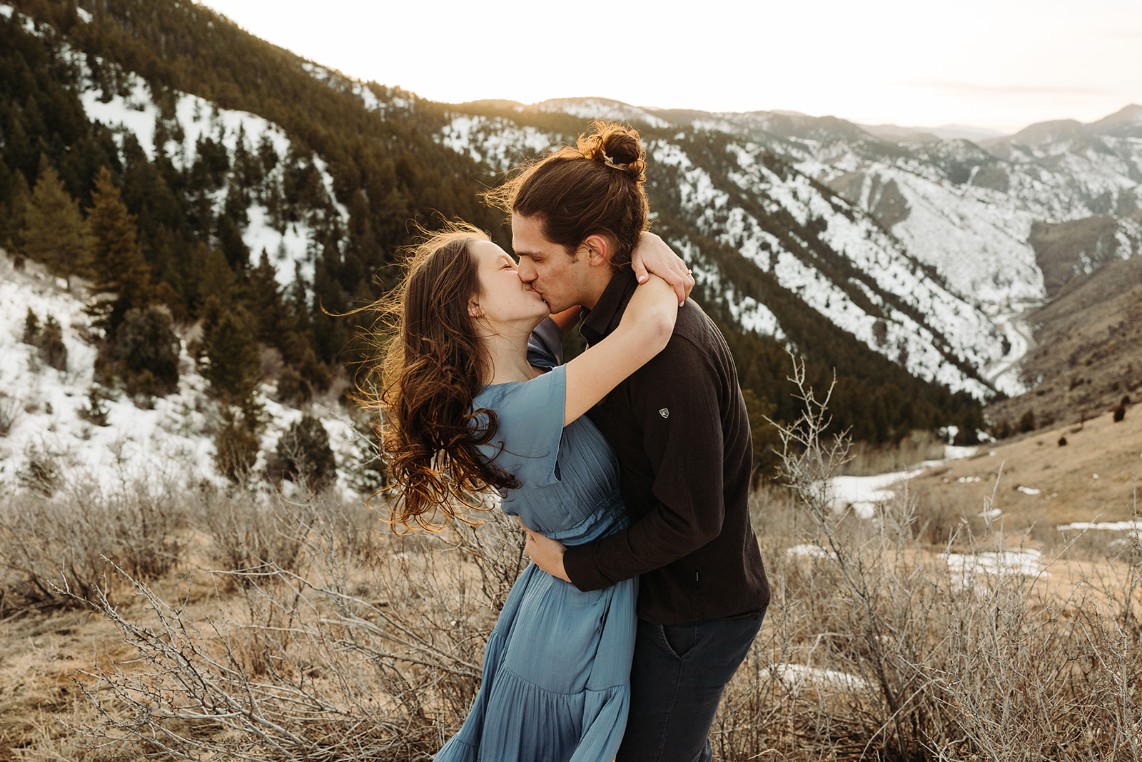 man and woman kissing in the mountains of Colorado during their spring engagement session