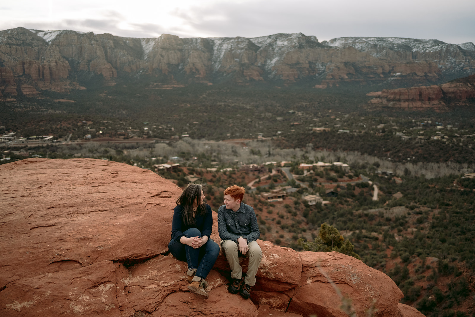 mother and son sitting together on Sedona red rocks