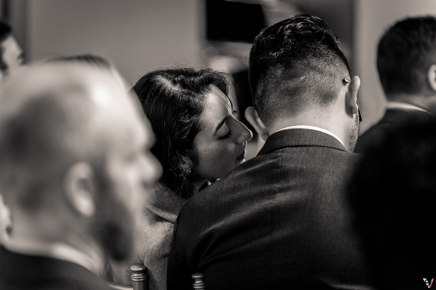 Guests whisper at a wedding ceremony. 