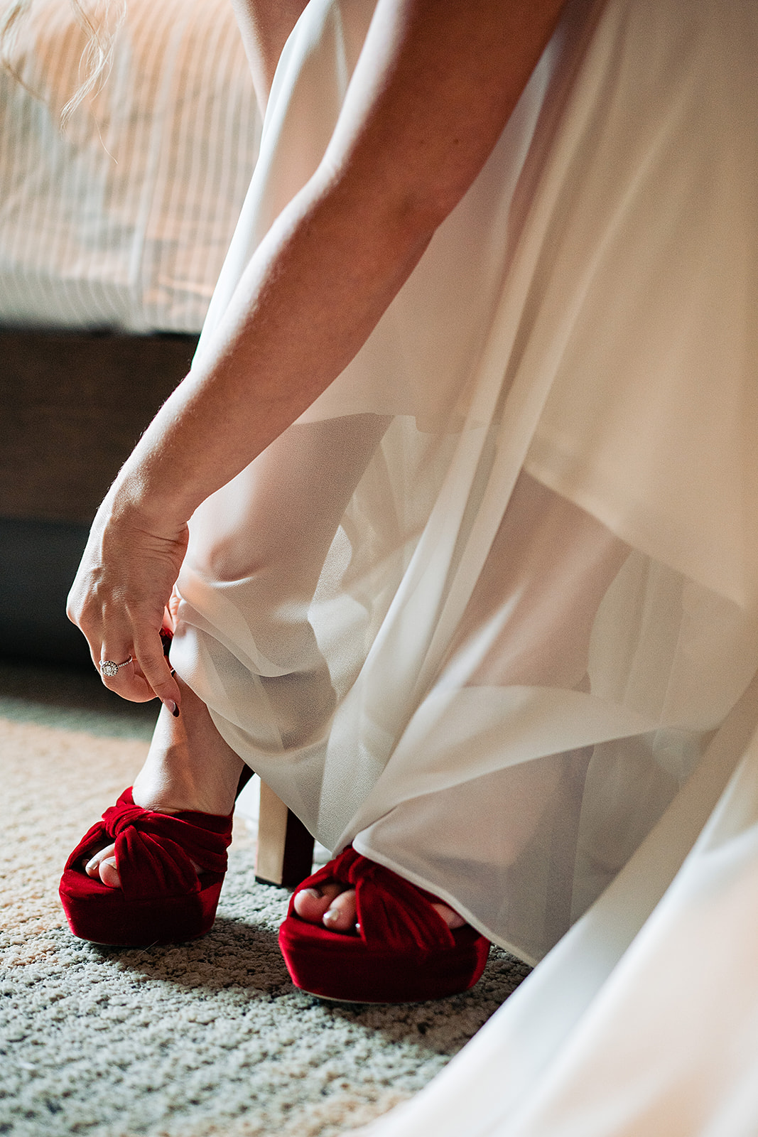 bride tying her red jimmy Choo shoes 