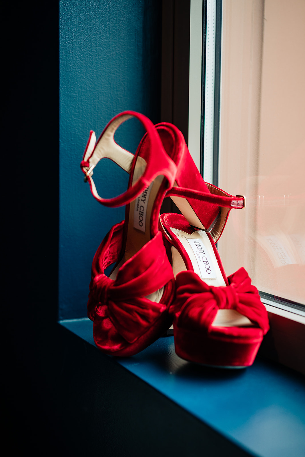 bright red jimmy Choo wedding shoes sitting on a window in philly 