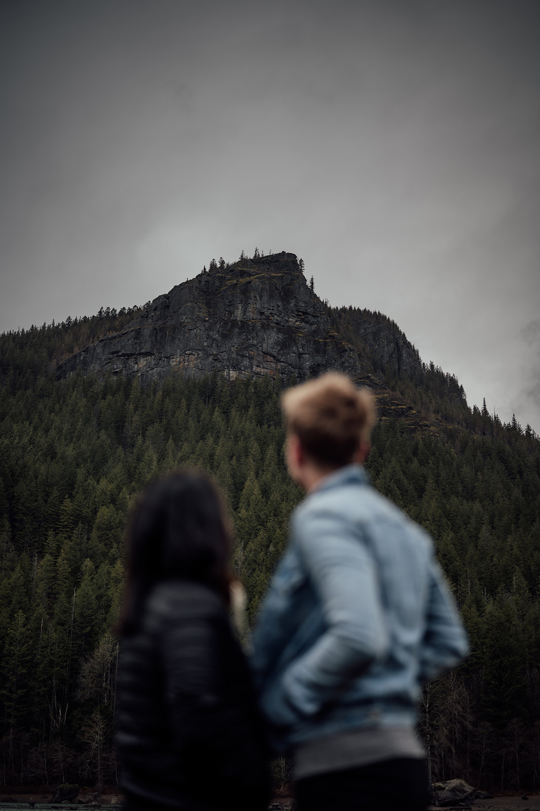 LGBTQIA+ couple looking up at the mountains near Rattlesnake Lake in Washington