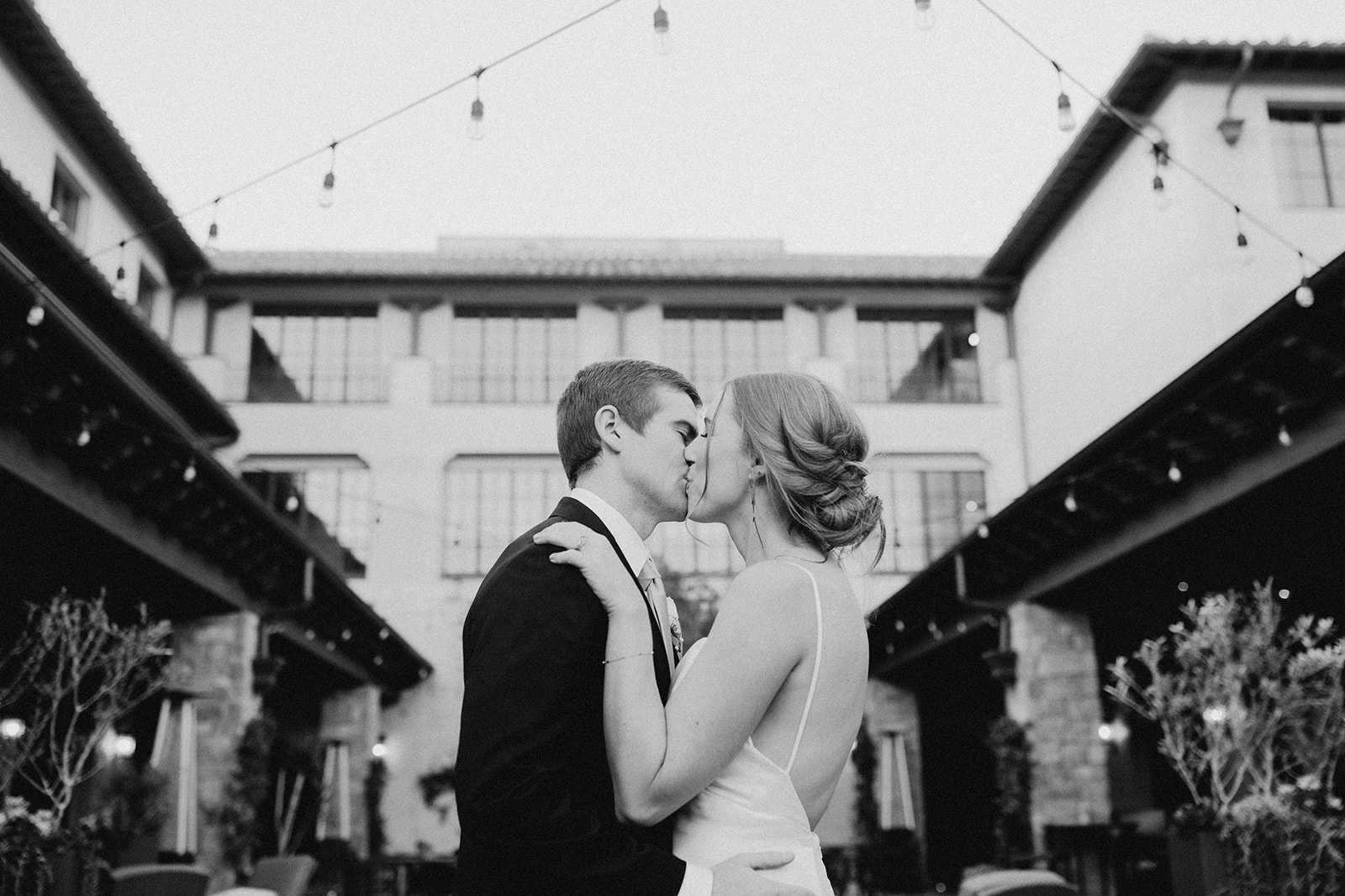 black and white photo of married couple kissing
