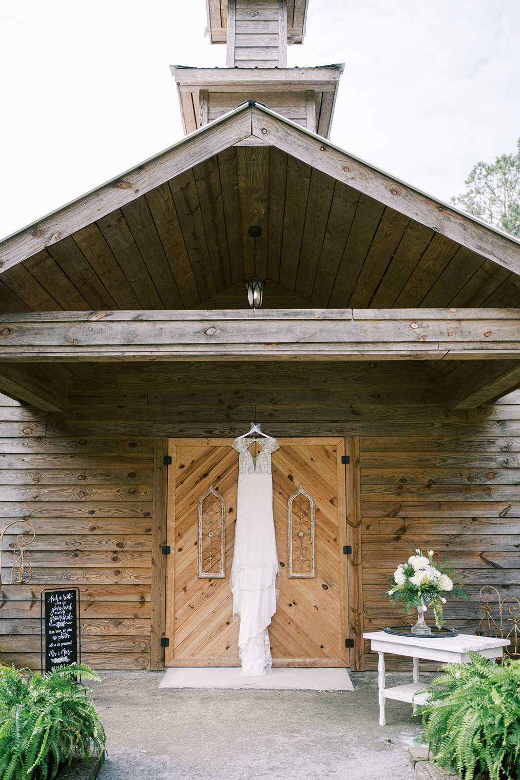 The wedding dress from Weddings, Pageants, & Proms hangs on the door at Dry Creek Chapel