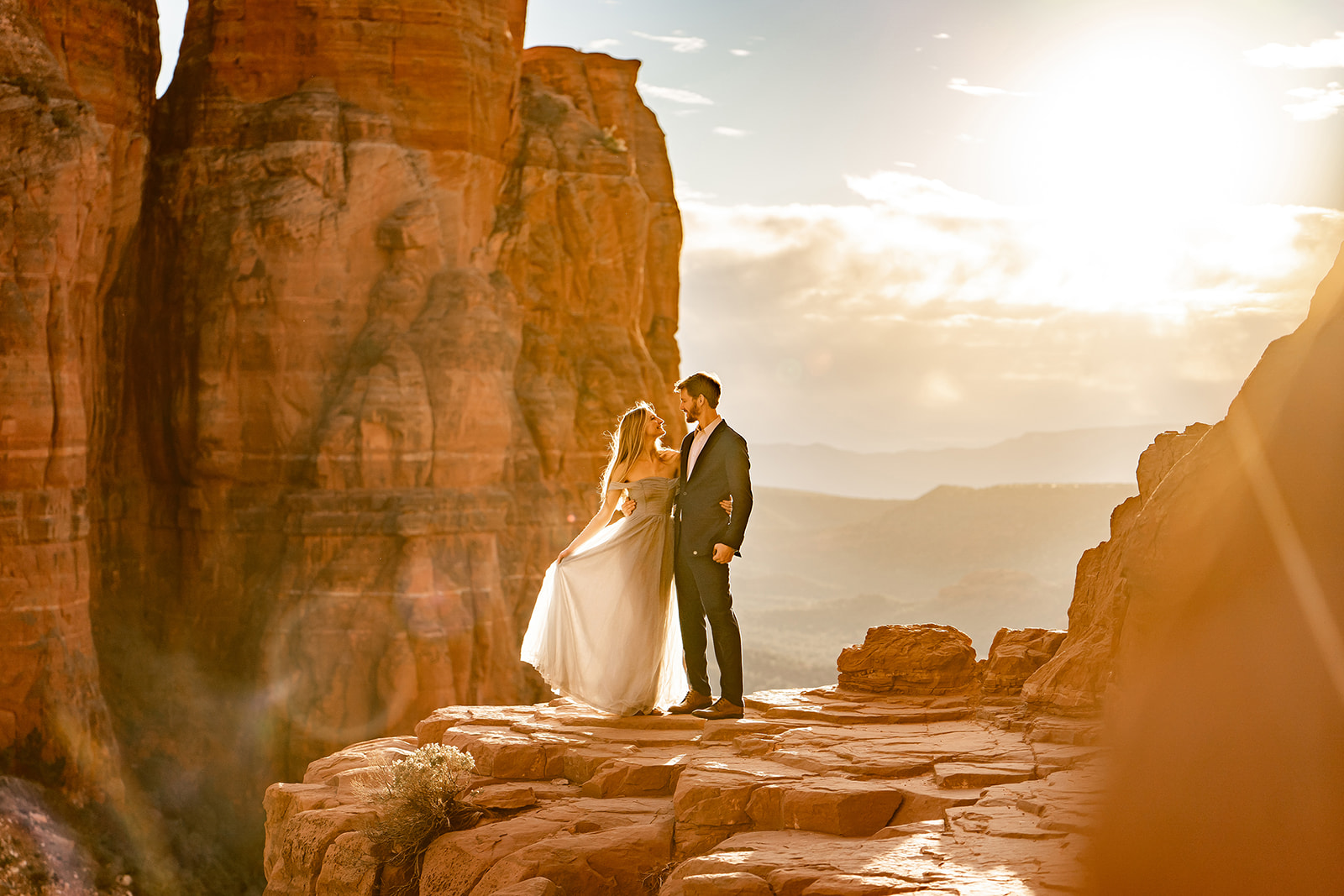 Couple at Cathedral Rock standing on ledge at sunset