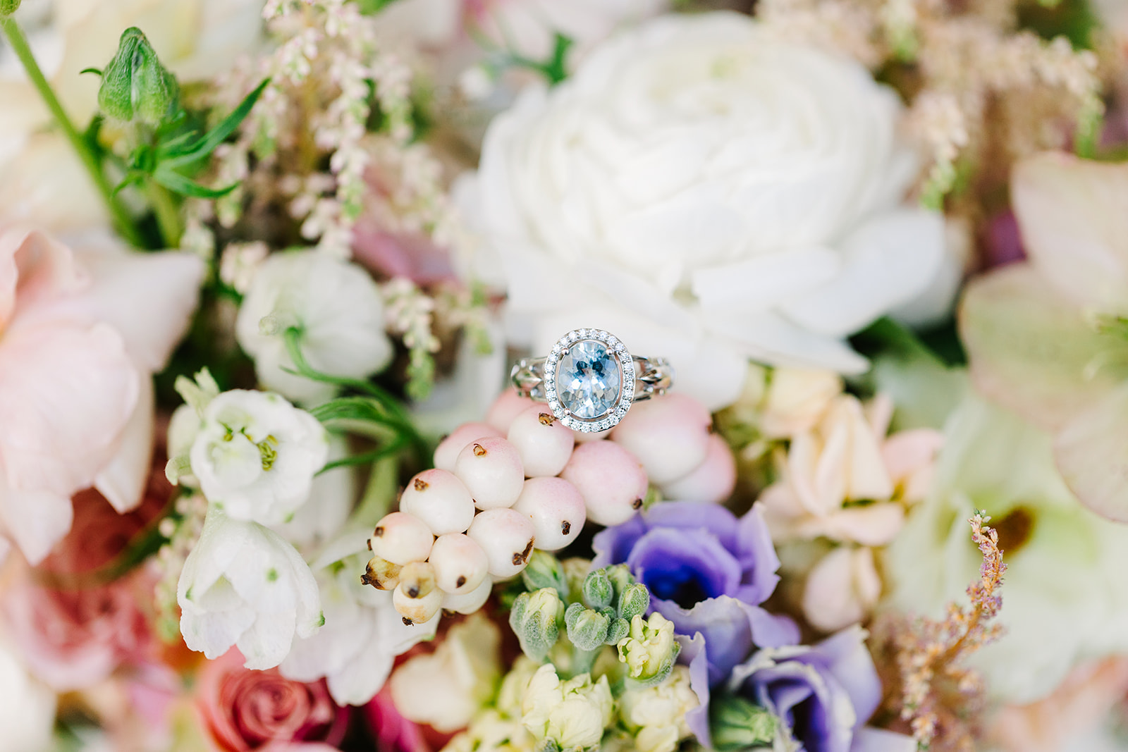 Engagement ring sitting on top of a spring time wedding bouquet