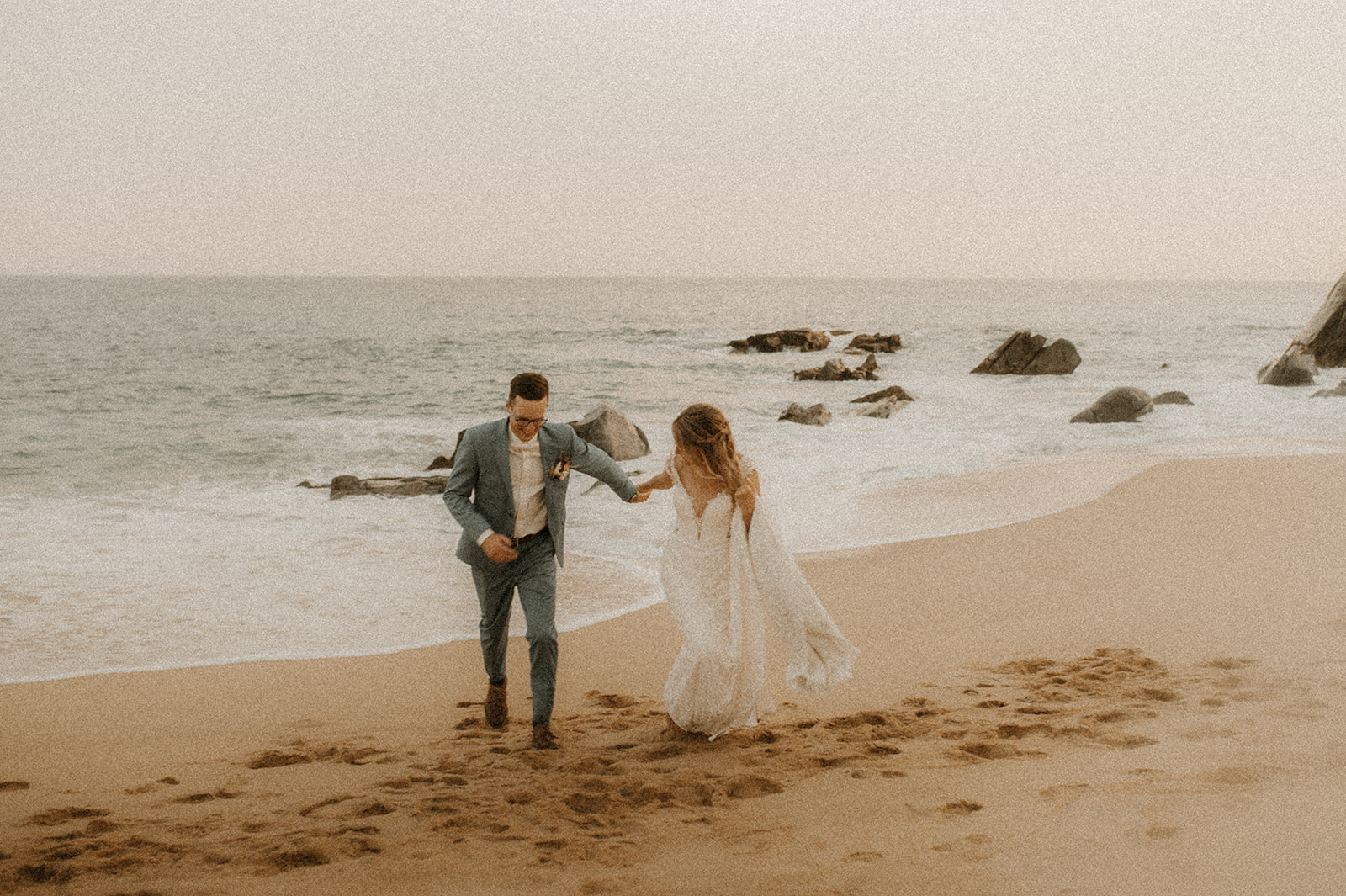A couple on the beach after their destination wedding in Cabo